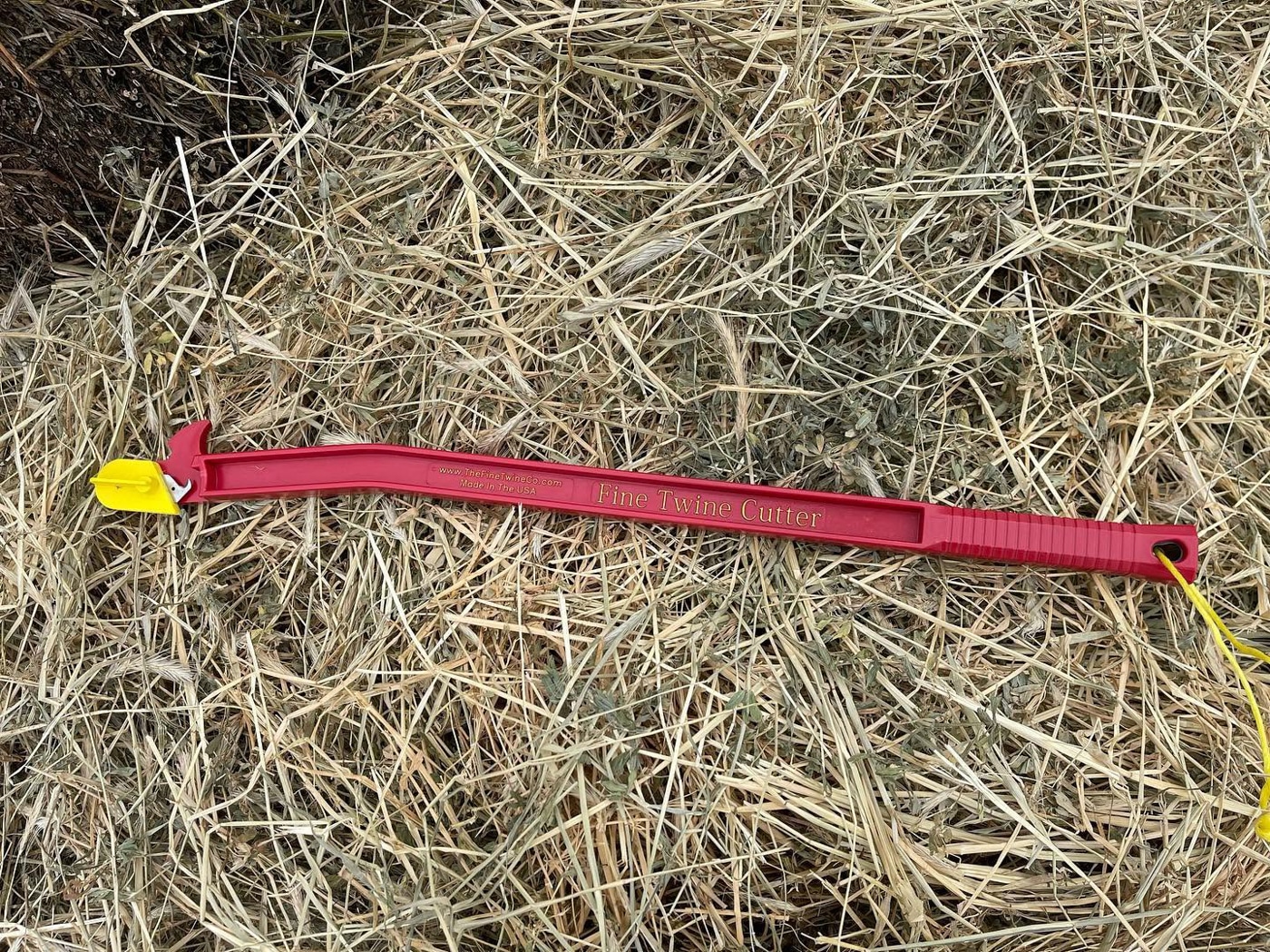 Fine Twine Cutter lying on freshly cut hay