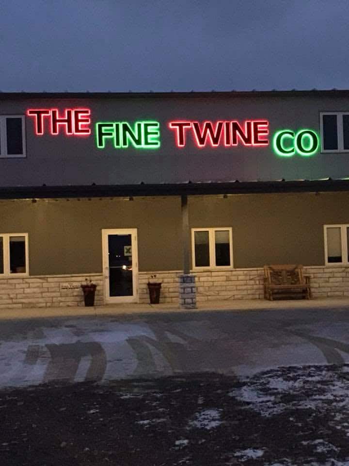 The Fine Twine Co. storefront in Alton, Iowa lit up at dusk